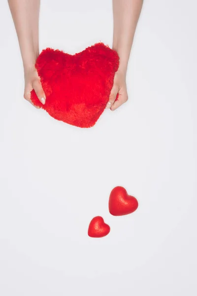 Recortado disparo de mujer apretando suave almohada corazón rojo aislado en blanco - foto de stock