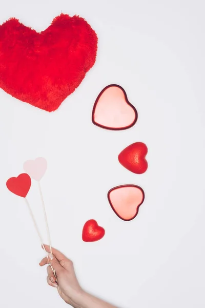 Recortado disparo de mujer sosteniendo corazones en palos cerca de San Valentín composición de vacaciones aislado en blanco - foto de stock