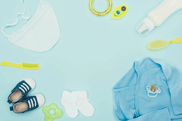 Ansicht von Babykleidung und Babyausrüstung isoliert auf blauem Grund — Stockfoto