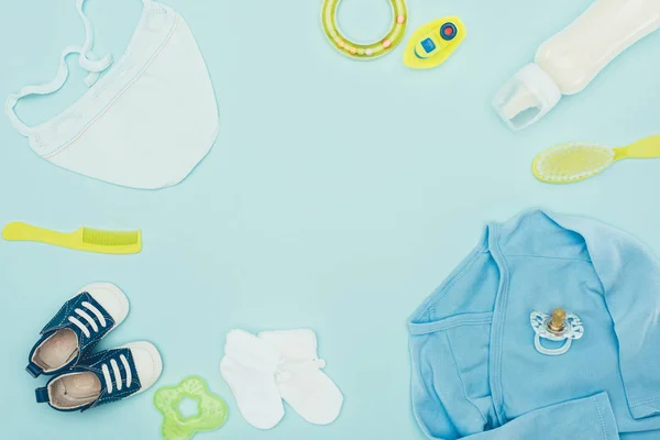 Top view of baby clothes and equipment isolated on blue — Stock Photo