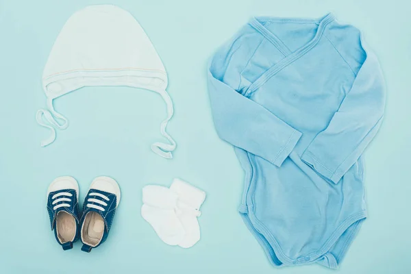 Top view of baby clothes isolated on blue — Stock Photo