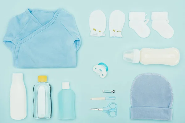 Top view of baby clothes and bathroom accessories isolated on blue — Stock Photo