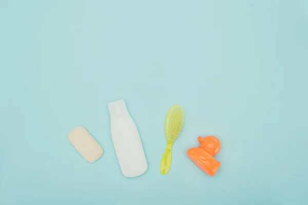 Top view of baby toy and bathroom accessories isolated on blue — Stock Photo