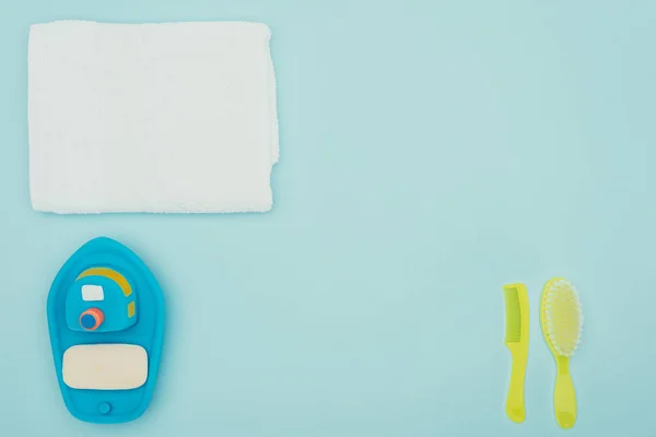 Top view of babys soap ant towel with combs isolated on blue — Stock Photo