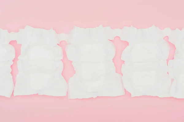 Top view of clean unused baby diapers isolated on pink — Stock Photo