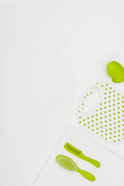 Top view of baby bib with towel and combs isolated on white — Stock Photo