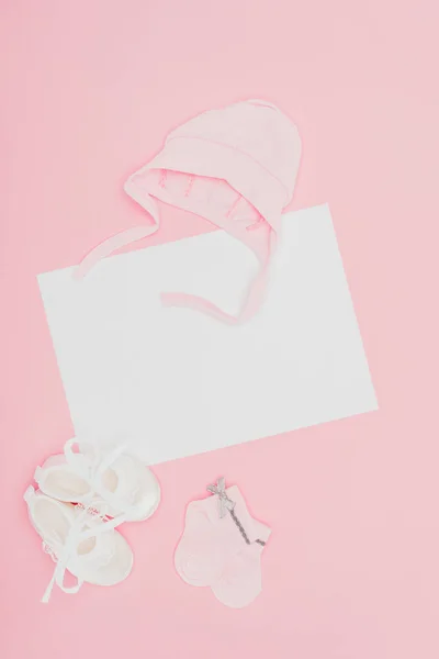 Top view of empty board with baby clothes isolated on pink — Stock Photo