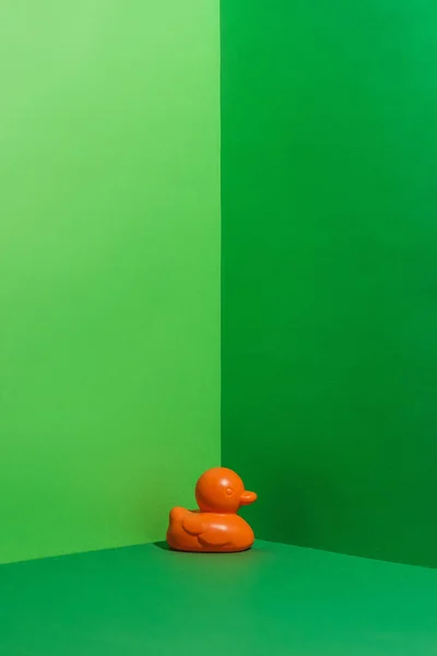 Childs orange rubber duck toy on green — Stock Photo