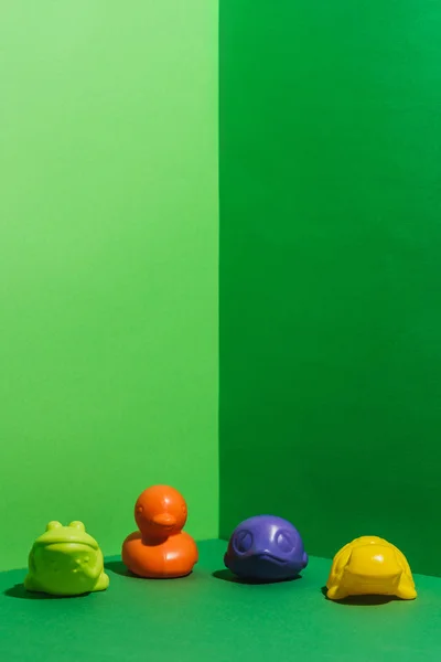 Colored baby toys in shape of animals on green — Stock Photo