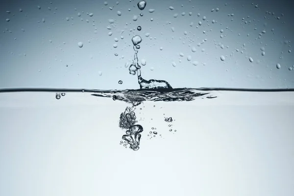 Fond minimaliste avec éclaboussures d'eau et bulles, isolé sur blanc — Photo de stock