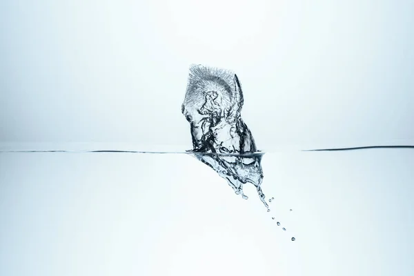 Ice cube splashing in water, isolated on white — Stock Photo