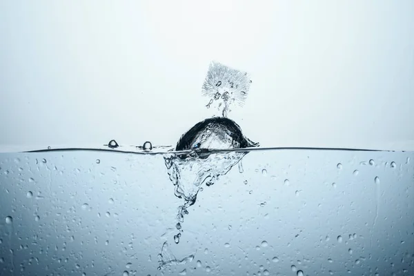 Cubo de hielo en agua con salpicadura, aislado en blanco - foto de stock