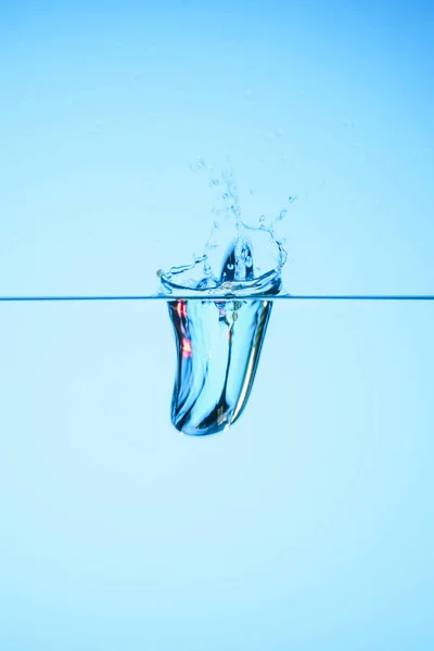 Reines Wasser mit Spritzwasser, isoliert auf blau — Stockfoto