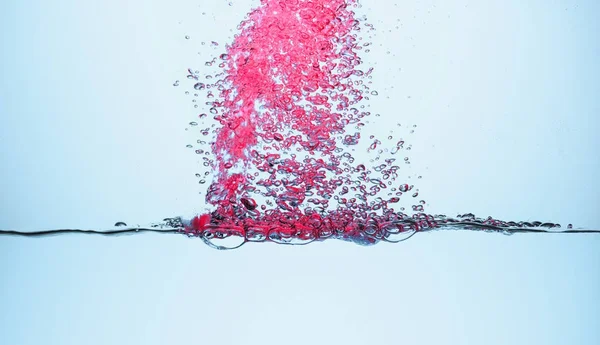 Burbujas rosadas en el agua, aisladas en blanco - foto de stock