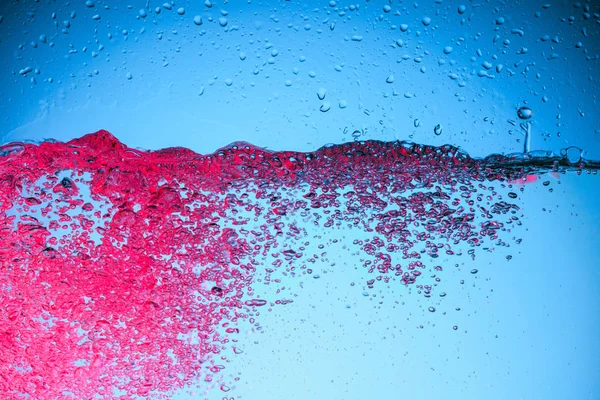 Burbujas rosadas en el agua, aisladas en azul - foto de stock