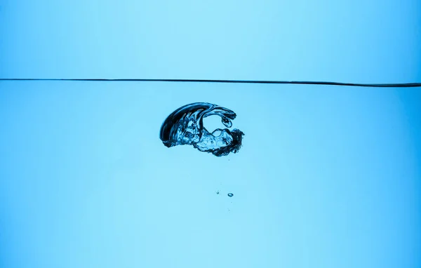 Gran burbuja en agua clara, aislado en azul - foto de stock