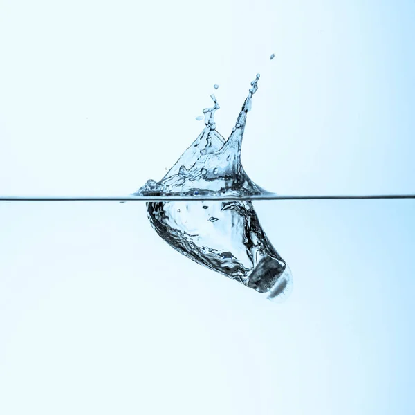 Cubo de hielo en agua clara, aislado en blanco - foto de stock