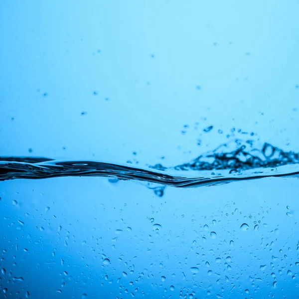 Fond d'eau coulant avec bulles et gouttes, isolé sur bleu — Photo de stock