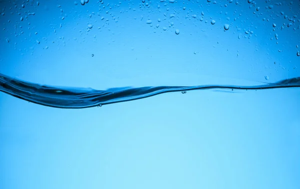 Texture fluide de l'eau avec des gouttes, isolé sur bleu — Photo de stock