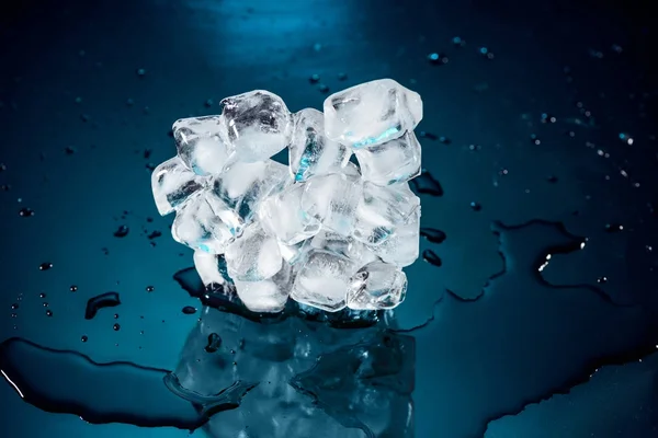 Eiswürfel auf Schwarz mit Wasser und Tropfen schmelzen — Stockfoto