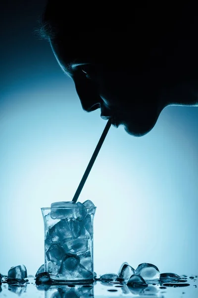 Profile silhouette of woman drinking cold water with ice — Stock Photo