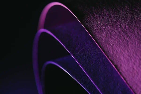 Закрыть вид на бумажные дуги друг на друга на темно-фиолетовом — стоковое фото