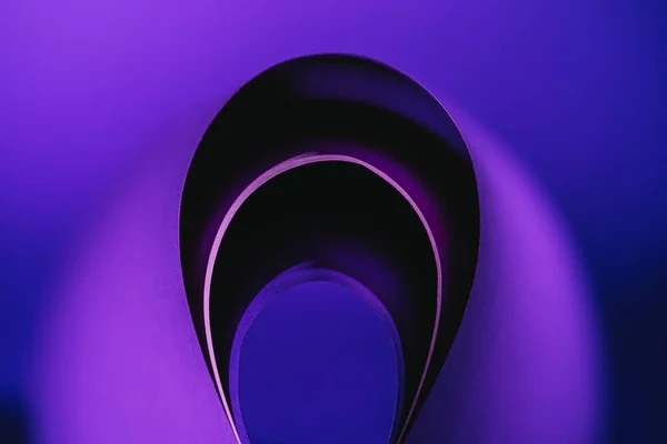 Дуги искривления фиолетовой бумаги на фиолетовом — стоковое фото
