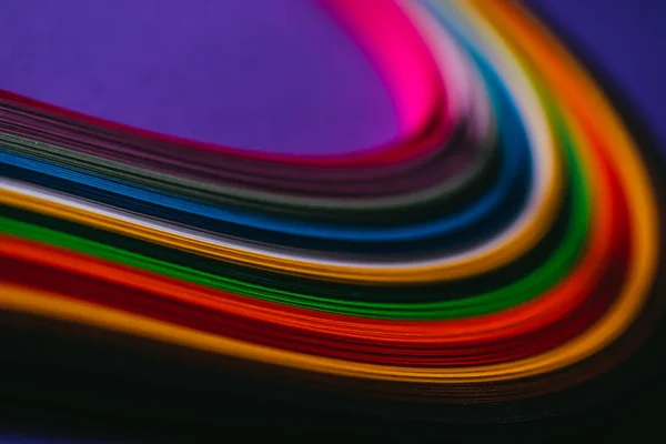 Strisce di carta quilling luminoso colorato su viola — Foto stock