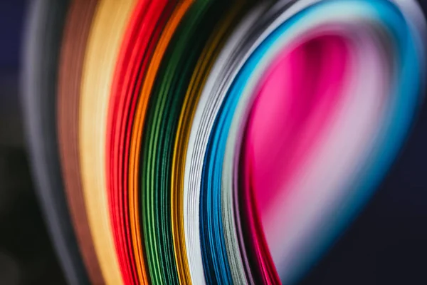 Fechar-se de curvas de papel quilling brilhantes coloridas no preto — Fotografia de Stock