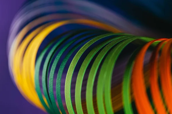 Крупним планом кольорові криві криволінійного паперу на фіолетовому — стокове фото