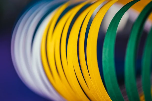 Primer plano de curvas de papel de molienda blanco, verde y amarillo sobre azul - foto de stock