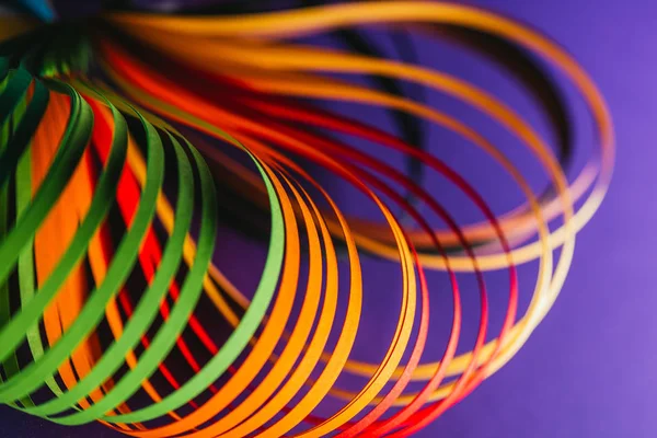 Close up of colored quilling paper curves on purple — Stock Photo