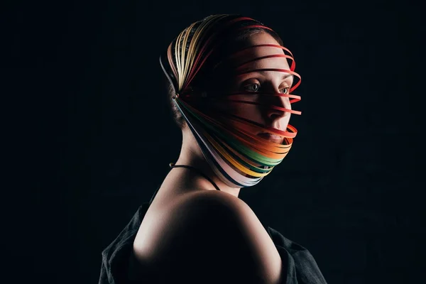 Портрет жінки з кольоровим креслярським папером на голові ізольовано на чорному — стокове фото