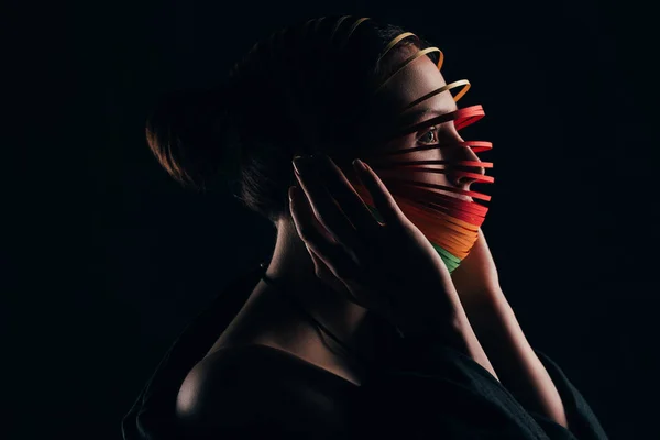 Vista laterale della donna con carta da trapunta colorata sulla testa isolata su nero — Foto stock