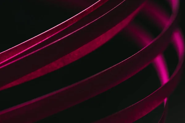 Close up view of crimson quilling striped paper on black — Stock Photo