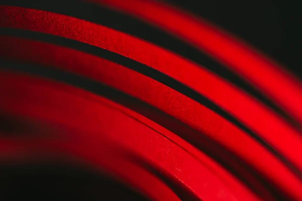 Close up view of red quilling striped paper on black — Stock Photo