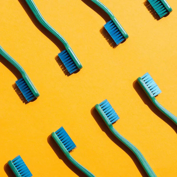 Fond minimaliste avec brosses à dents vertes, sur fond jaune — Photo de stock