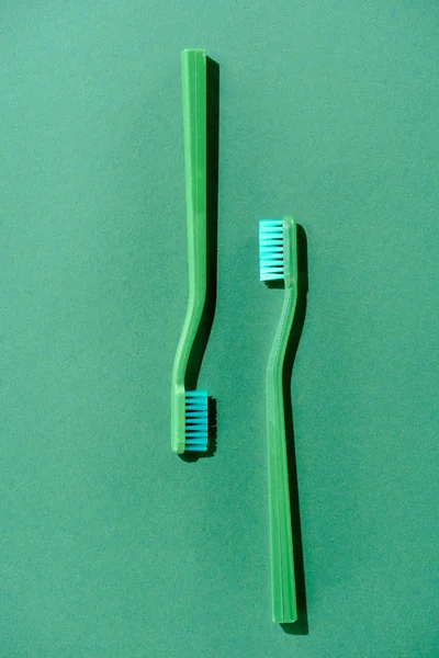 Top view of green toothbrushes, on green — Stock Photo