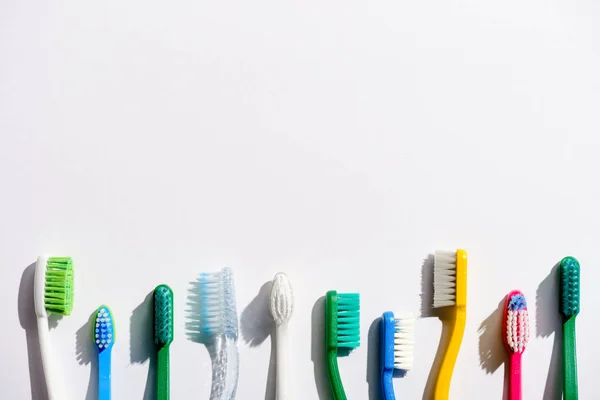 Rangée de brosses à dents différentes, sur blanc avec espace de copie — Photo de stock