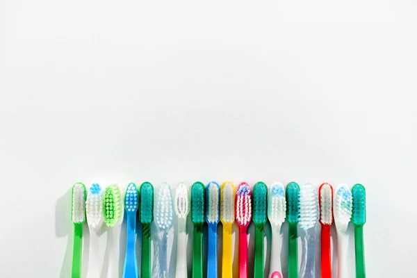 Row of different colorful toothbrushes, on white with copy space — Stock Photo