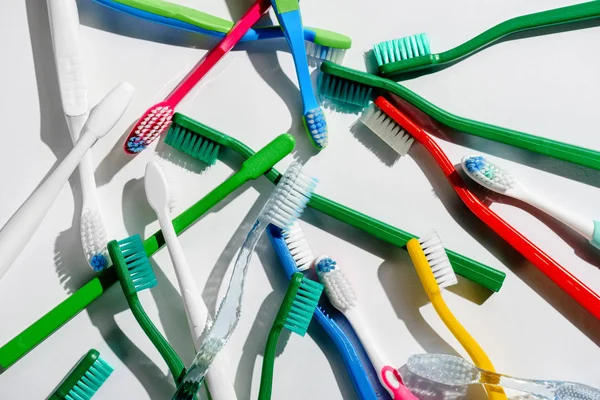 Fond avec brosses à dents colorées pour l'hygiène du matin, sur fond blanc — Photo de stock