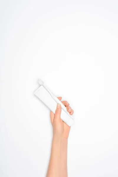 Cropped view of woman holding toothbrush and toothpaste, isolated on white — Stock Photo