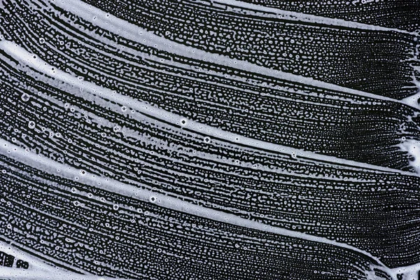 Vista superior de espuma de sabão na superfície preta — Fotografia de Stock