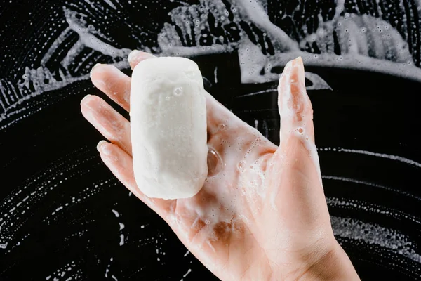 Cropped view of woman holding soap with foam — Stock Photo