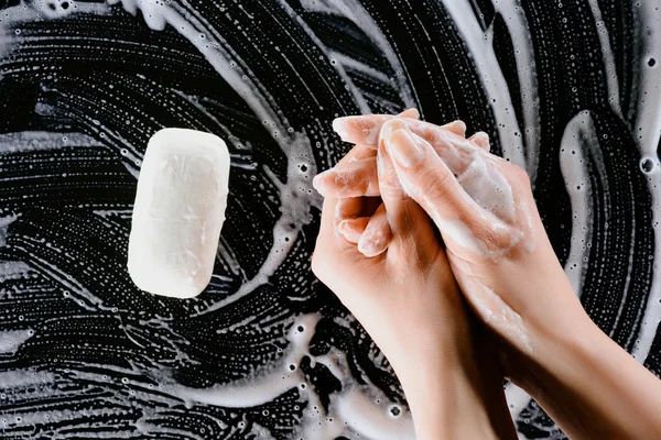 Vista recortada de la mujer lavándose las manos con espuma de jabón - foto de stock