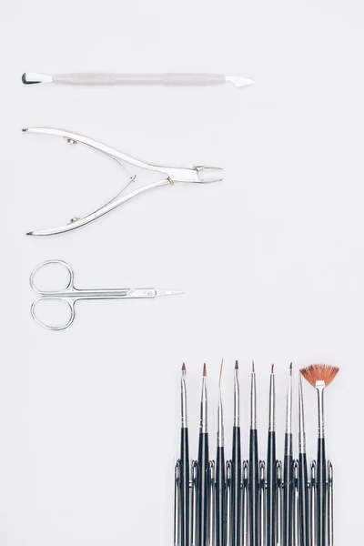 Vue de dessus des pinces à ongles et brosses isolées sur blanc — Photo de stock