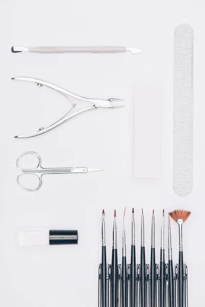 Vista superior de linhas de ferramentas de manicure isoladas em branco — Fotografia de Stock