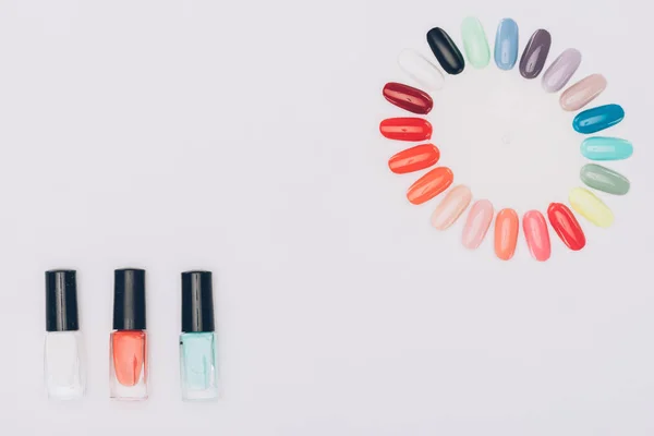 Vista superior de esmaltes coloridos e paleta de manicure isolado em branco — Fotografia de Stock