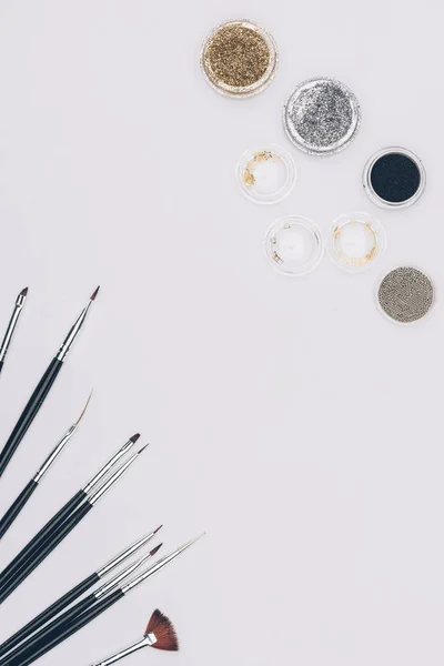 Top view of brushes and glitter isolated on white — Stock Photo