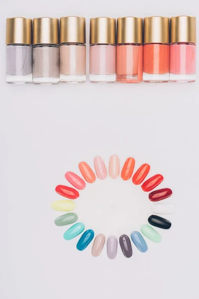 Top view of row of nail polishes and palette isolated on white — Stock Photo